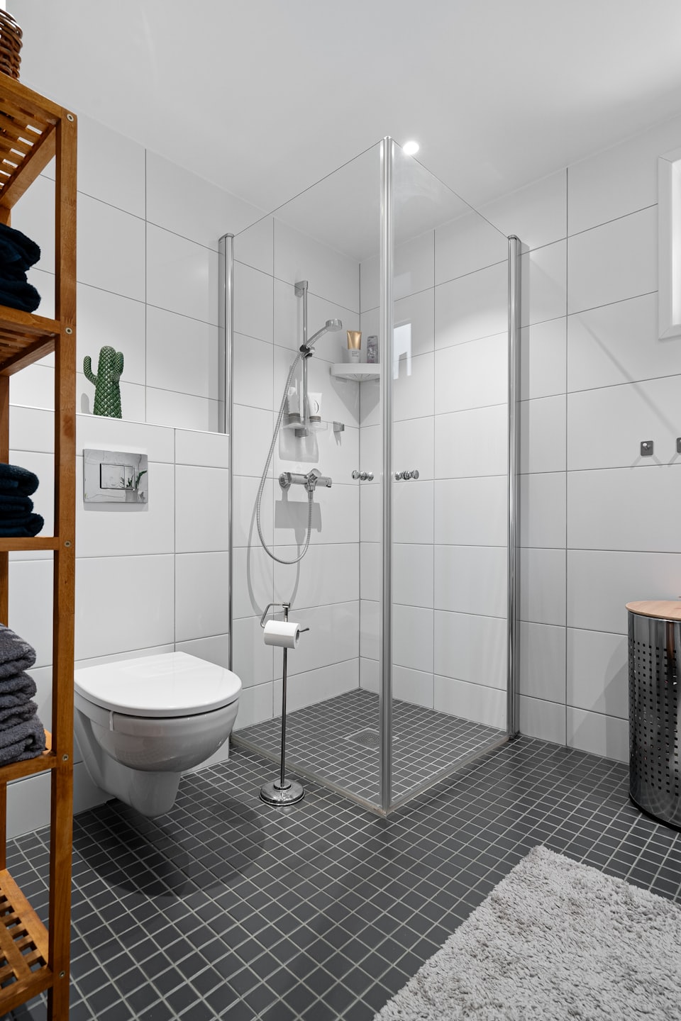 Bagno moderno con doccia e asciugamani ben impilati.